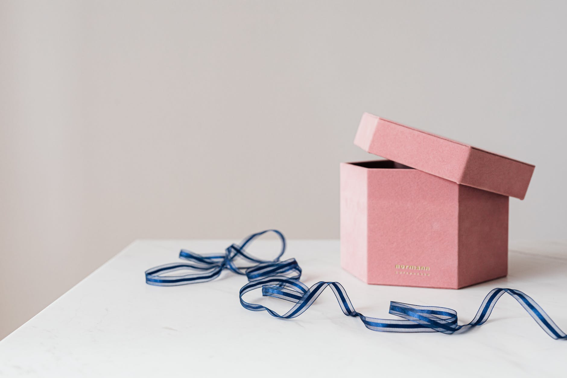 pink hexagon present box and blue ribbon on table